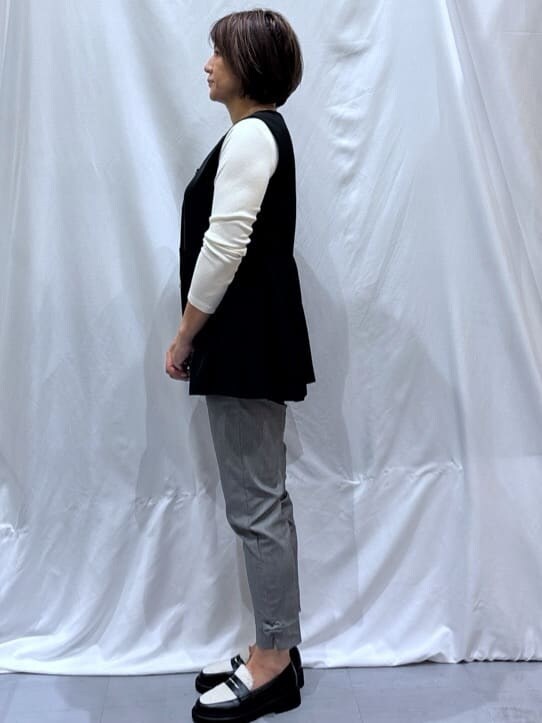 ブラック系のベスト、ホワイト系のTシャツ/カットソー、グレー系のその他パンツを着用したレディースの秋コーディネートの3枚目の写真