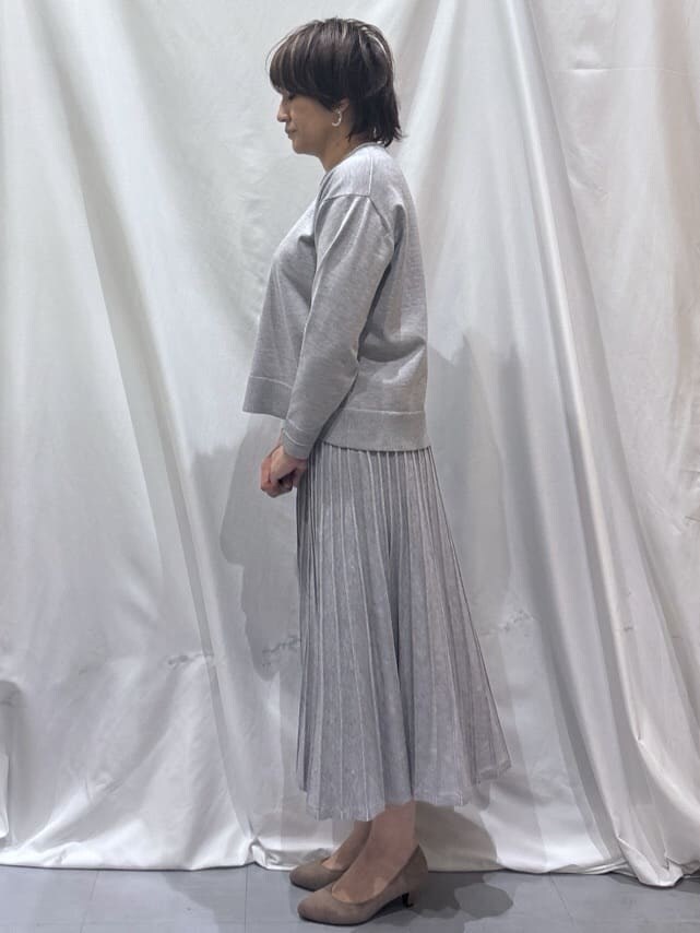 グレー系のニット/セーター、グレー系のスカート、ベージュ系のパンプスを着用したレディースの冬コーディネートの2枚目の写真