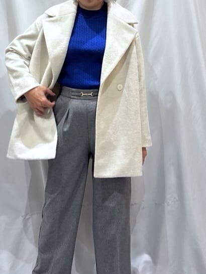 ベージュ系のチェスターコート、ブルー系のニット/セーター、グレー系のその他パンツを着用したレディースの冬コーディネートの4枚目の写真