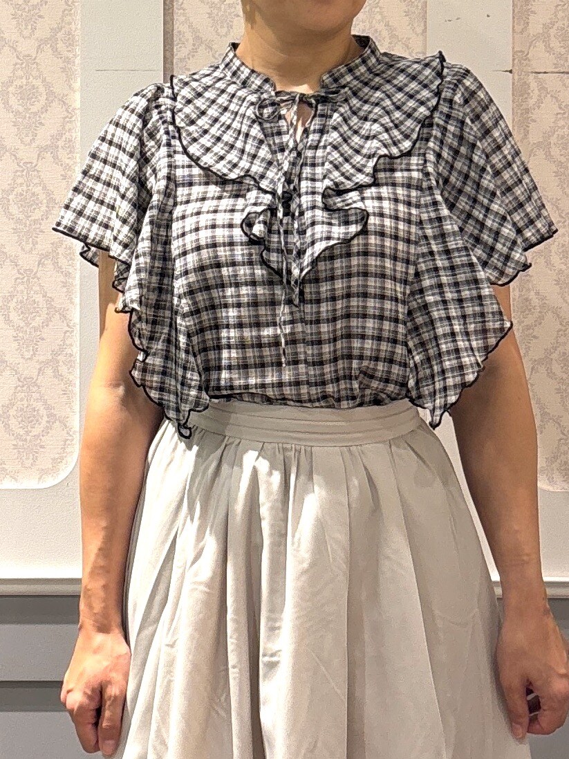 ブラック系のシャツ/ブラウス、ベージュ系のスカートを着用したレディースの夏コーディネートの4枚目の写真