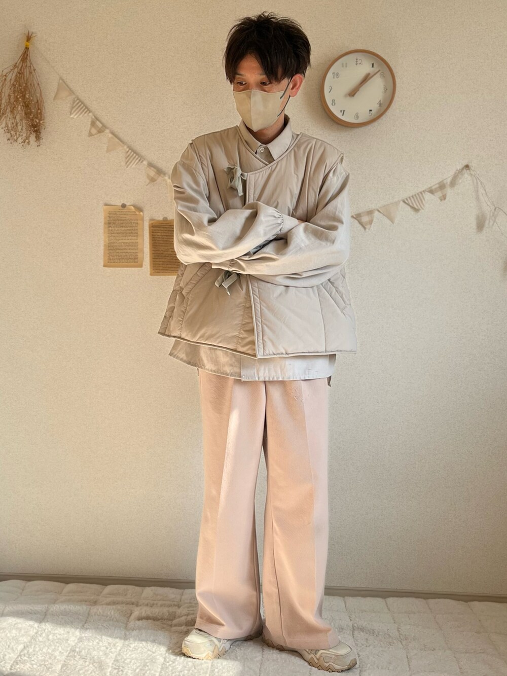 ベージュ系のベスト、ホワイト系のスラックス、ベージュ系のスニーカーを着用したメンズの冬コーディネートの2枚目の写真