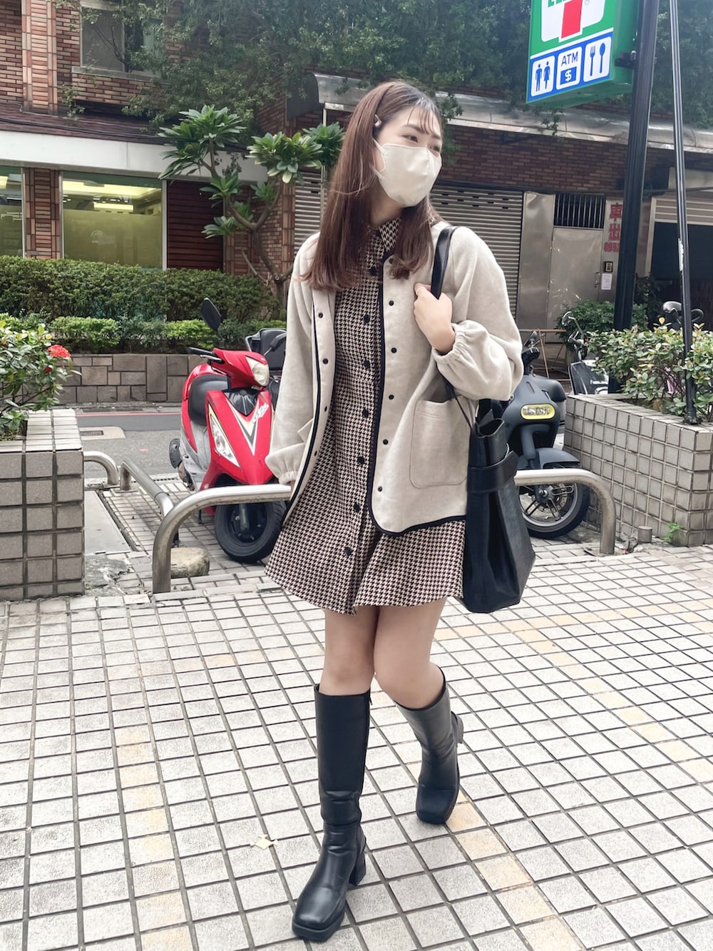 ブラック系のブーツ、ベージュ系のワンピース、ブラック系のドラムバッグを着用したレディースの秋コーディネートの2枚目の写真