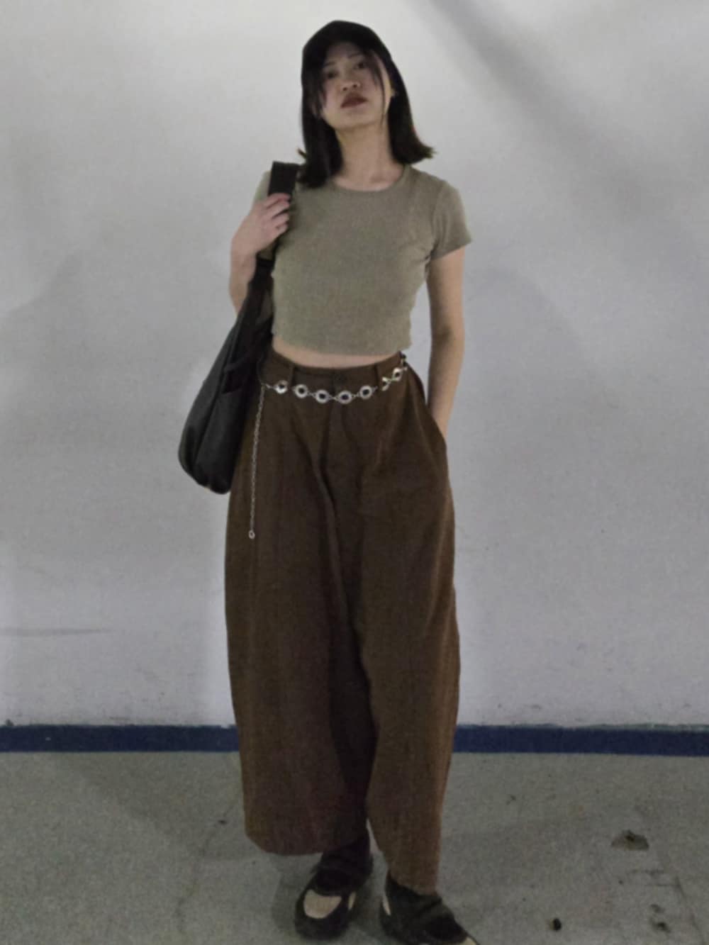 グリーン系のTシャツ/カットソー、ブラウン系のバッグ、ブラウン系のチノパンツを着用したレディースの春コーディネートの2枚目の写真