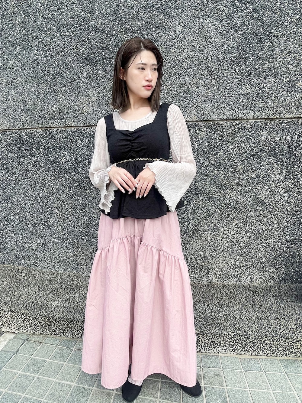 ピンク系のスカート、ブラック系のシューズ、ブラック系のトップスを着用したレディースの冬コーディネートの2枚目の写真