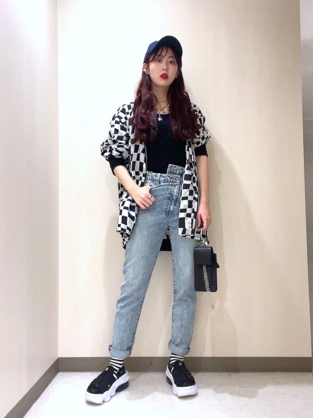 ブラック系のニット/セーター、ブラック系のMA-1、ブルー系のデニムパンツを着用したレディースの春コーディネートの3枚目の写真