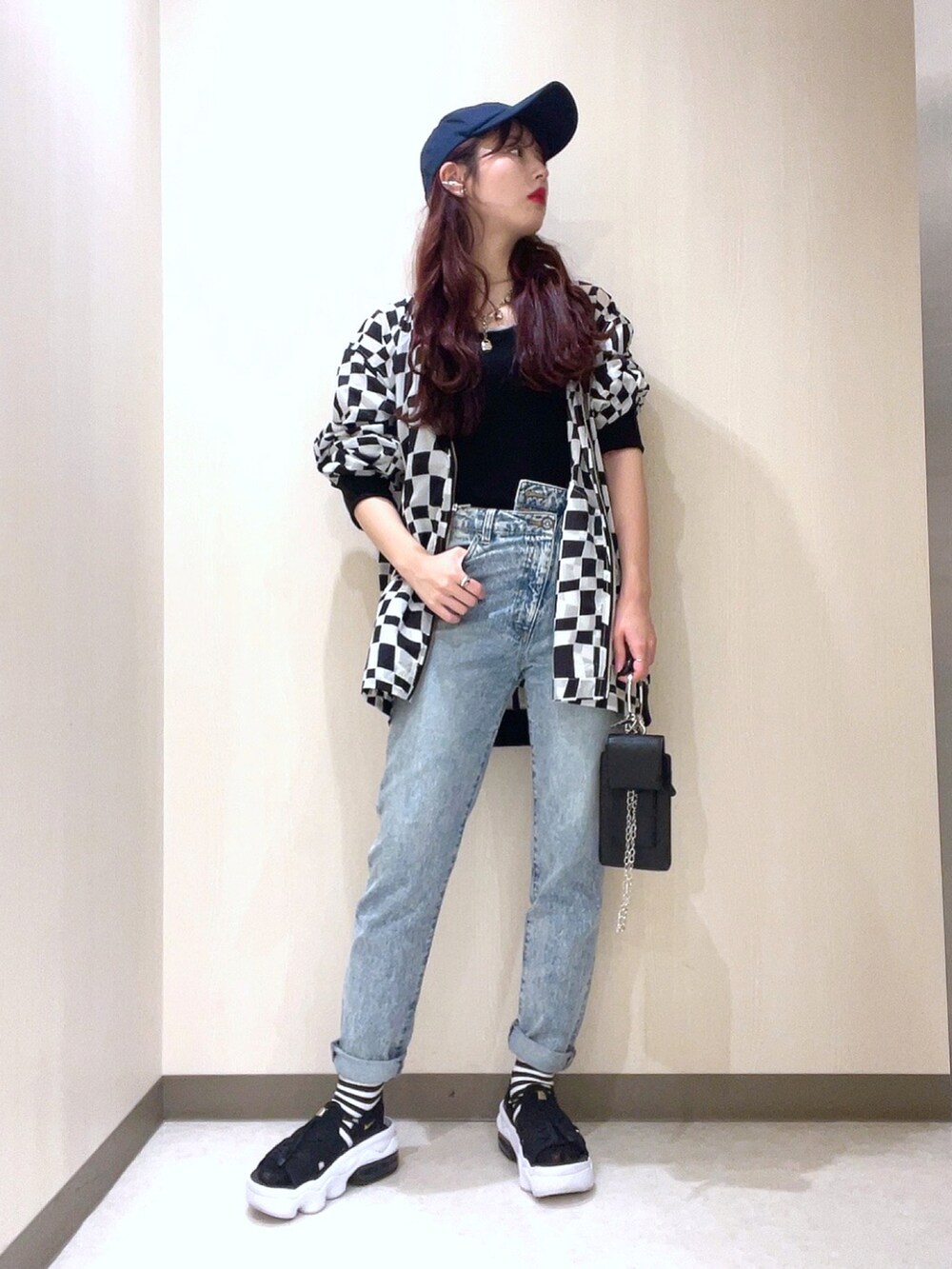 ブラック系のニット/セーター、ブラック系のMA-1、ブルー系のデニムパンツを着用したレディースの春コーディネートの2枚目の写真