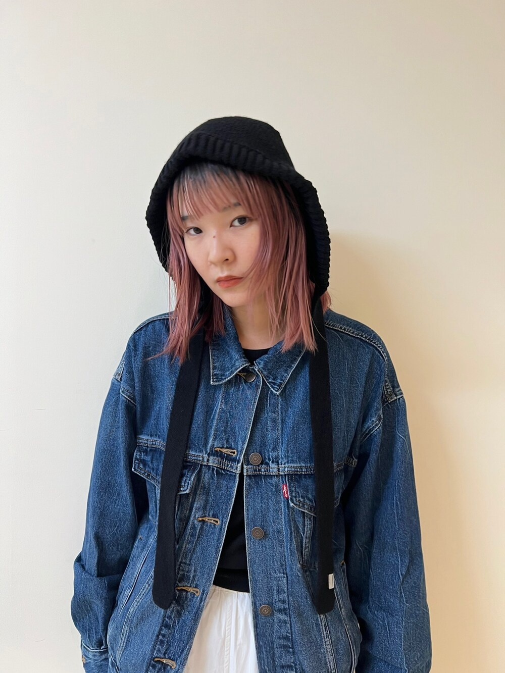 ブルー系のデニムジャケット、ホワイト系のカーゴパンツ、ブラック系のハットを着用したレディースの秋コーディネートの3枚目の写真