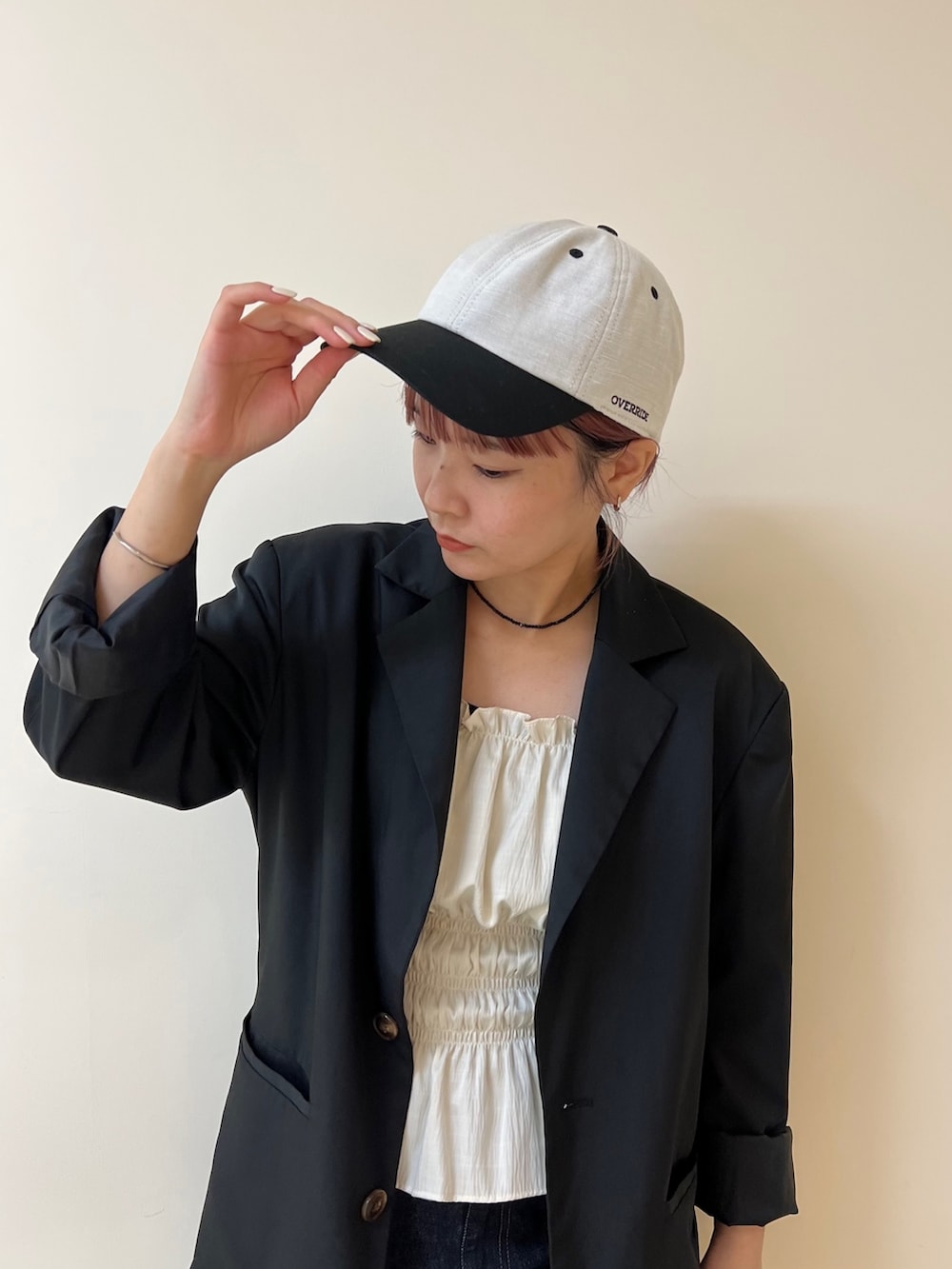 ブラック系のテーラードジャケット、ブルー系のデニムパンツ、ブラック系のブーツを着用したレディースの夏コーディネートの2枚目の写真