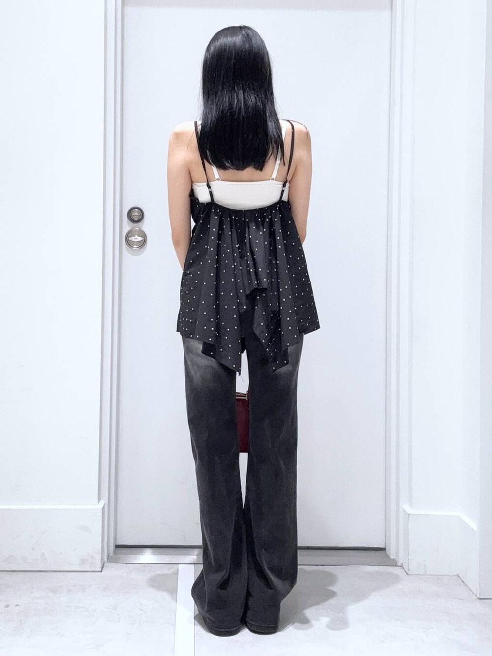 ブラック系のデニムパンツ、レッド系のボストンバッグ、ブラック系のキャミソールを着用したレディースの夏コーディネートの3枚目の写真