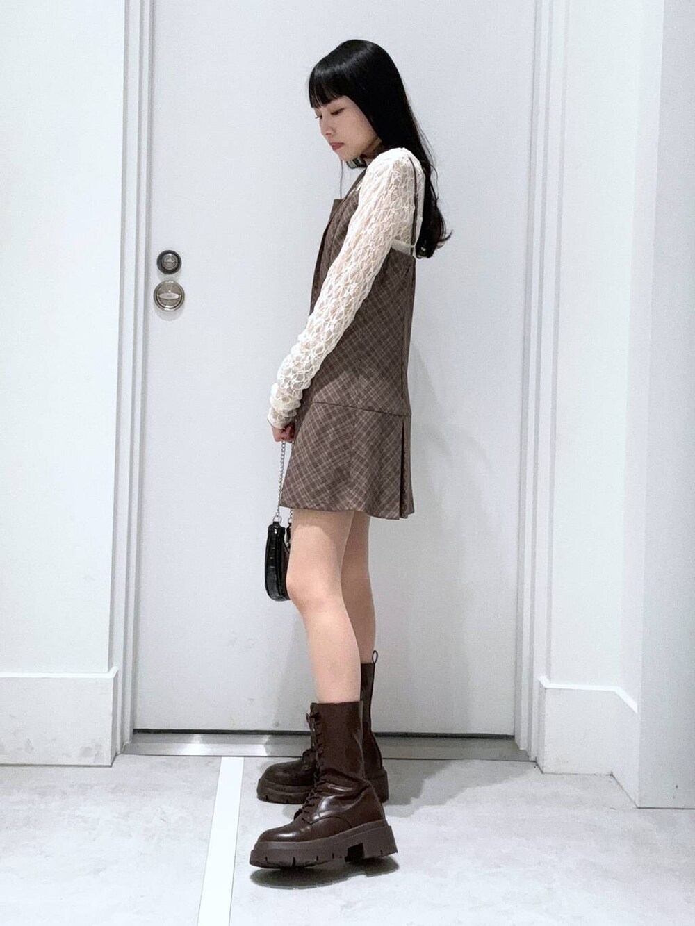 ホワイト系のTシャツ/カットソー、ベージュ系のワンピース、ブラック系のその他パンツを着用したレディースの春コーディネートの2枚目の写真