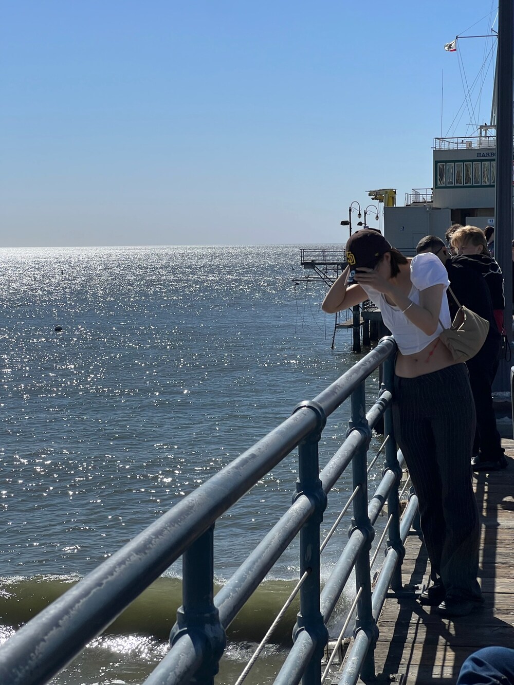 グレー系のパンツ、ホワイト系のシャツ/ブラウス、ブラウン系のショルダーバッグを着用したレディースの冬コーディネートの2枚目の写真