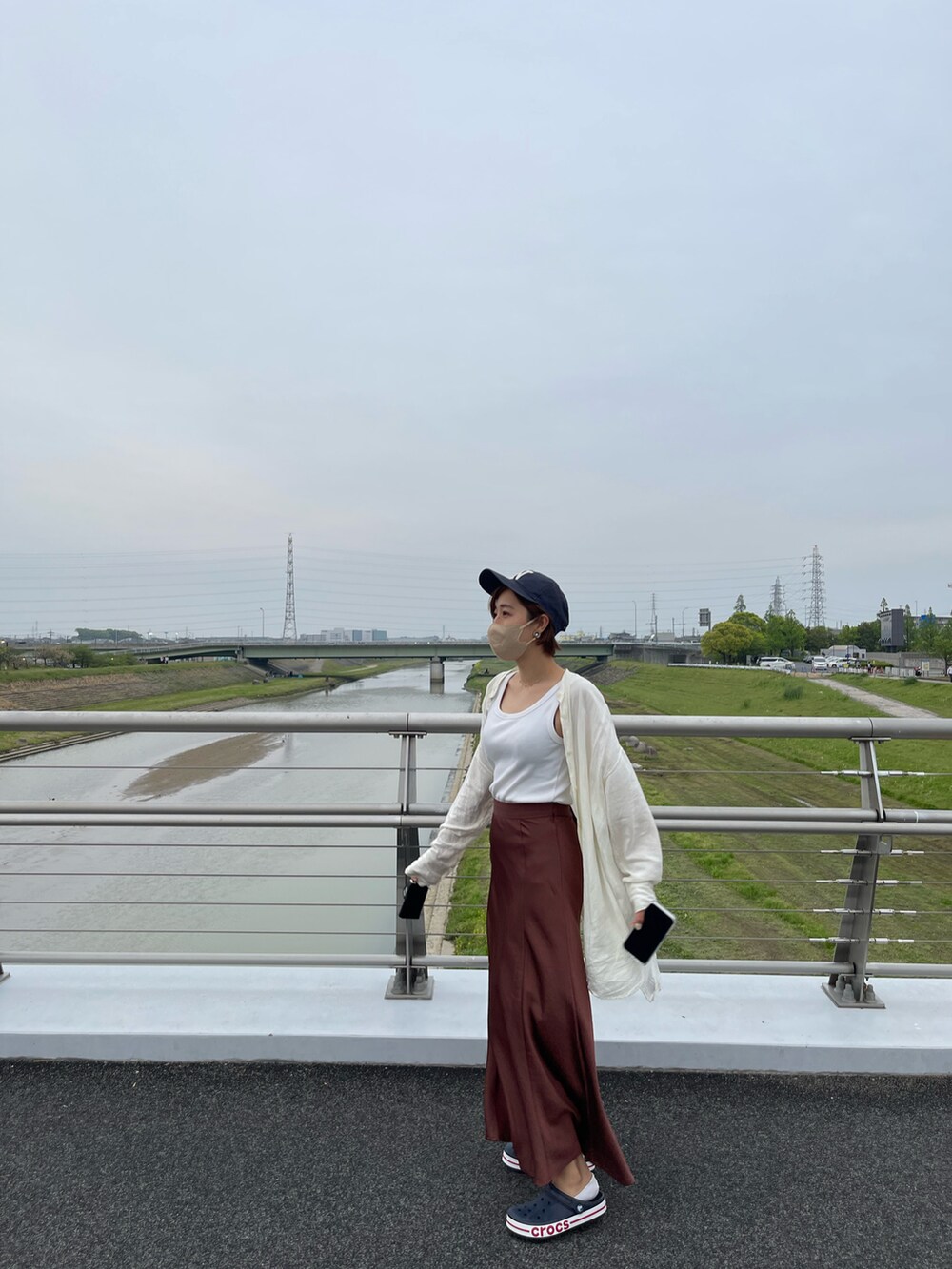 ブラウン系のスカート、ホワイト系のキャミソール、ベージュ系のシャツ/ブラウスを着用したレディースの春コーディネートの2枚目の写真