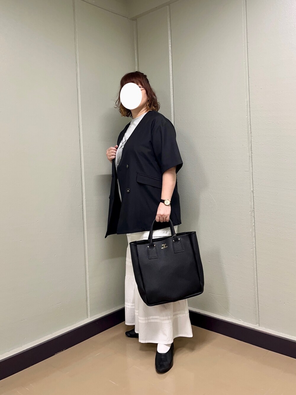 ブラック系のノーカラージャケット、グレー系のTシャツ/カットソー、ホワイト系のスカートを着用したレディースの春コーディネートの2枚目の写真