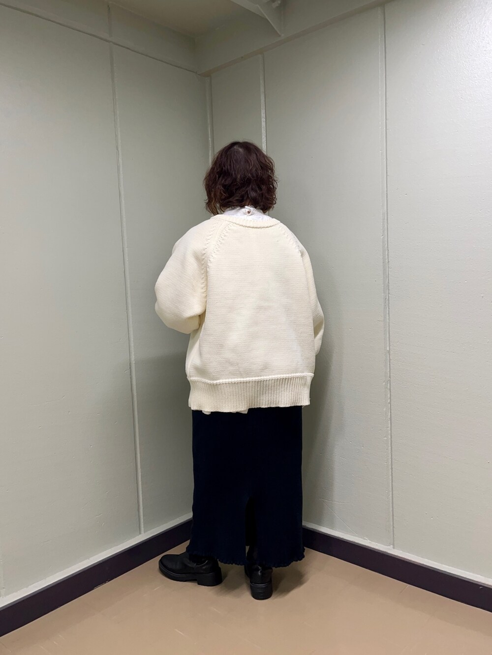 ホワイト系のニット/セーター、ホワイト系のシャツ/ブラウス、ブラック系のスカートを着用したレディースの冬コーディネートの4枚目の写真