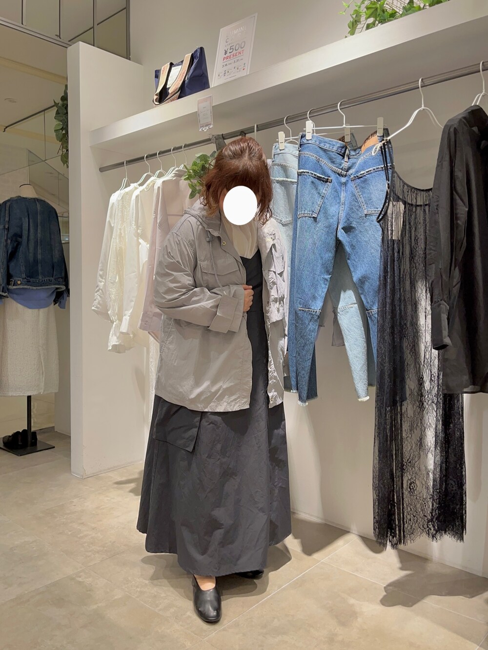 ホワイト系のシャツ/ブラウス、ブラック系のワンピース/ドレス、グレー系のマウンテンパーカーを着用したレディースの春コーディネートの2枚目の写真