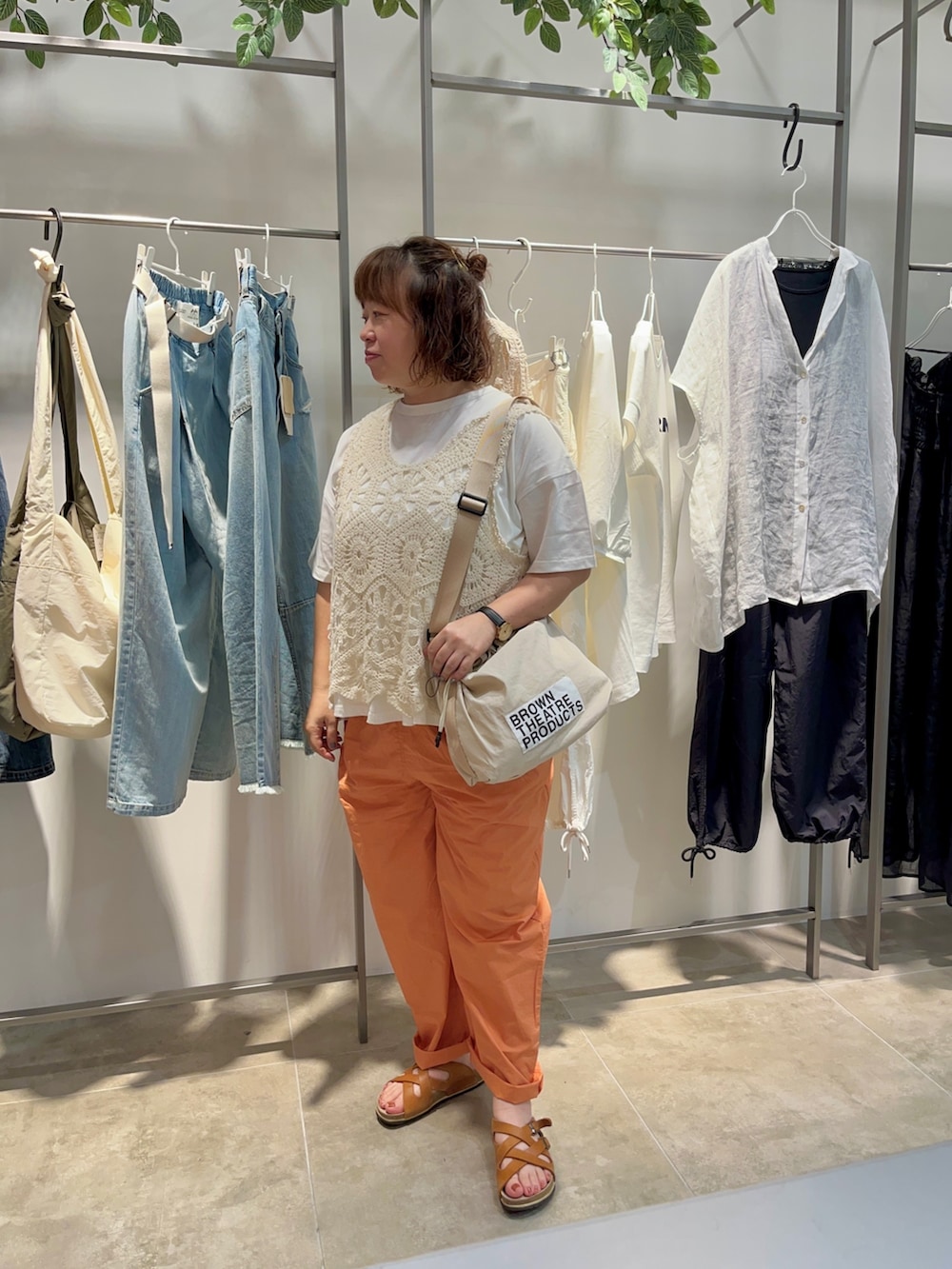 ホワイト系のTシャツ/カットソー、ベージュ系のベスト、オレンジ系のパンツを着用したレディースの夏コーディネートの3枚目の写真