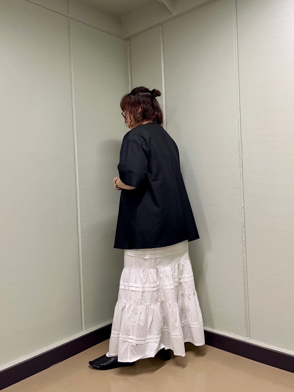 ブラック系のノーカラージャケット、グレー系のTシャツ/カットソー、ホワイト系のスカートを着用したレディースの春コーディネートの3枚目の写真