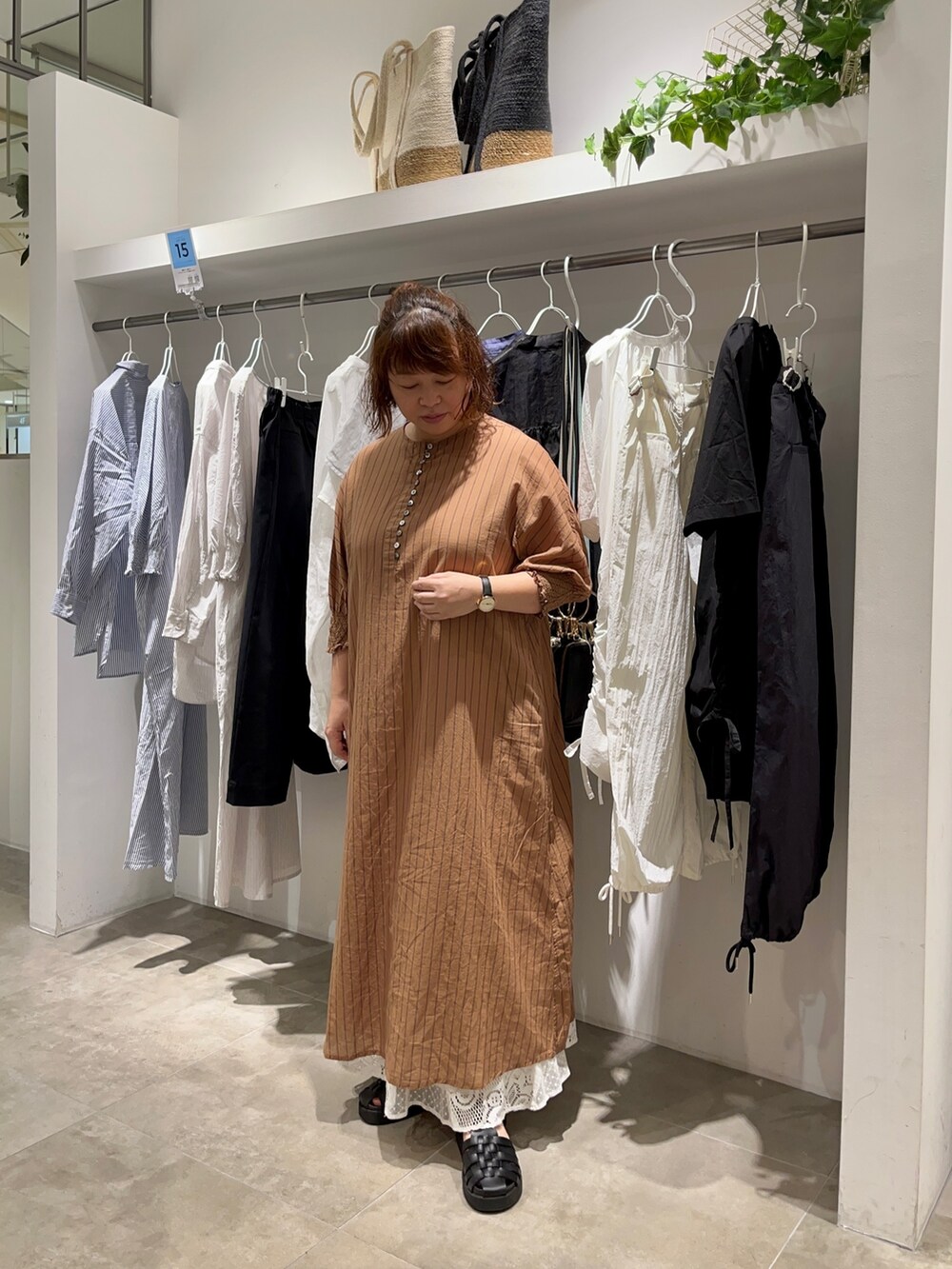 ブラウン系のワンピース、ホワイト系のスカート、ブラック系のショルダーバッグを着用したレディースの夏コーディネートの2枚目の写真