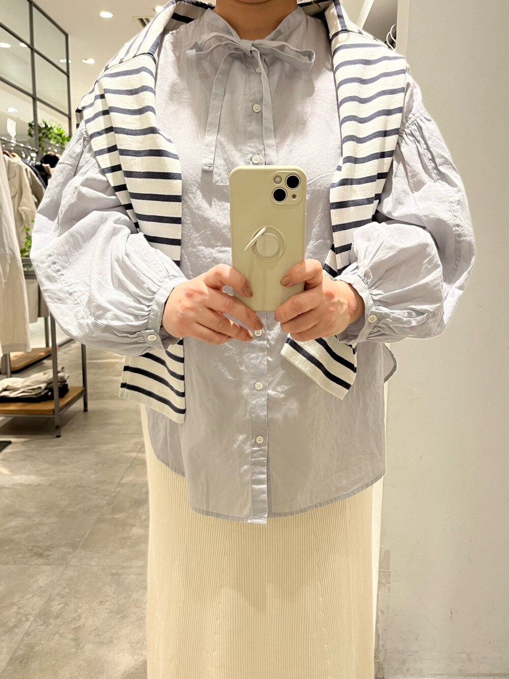 グレー系のシャツ/ブラウス、ホワイト系のスカート、ブラック系のシューズを着用したレディースの春コーディネートの2枚目の写真