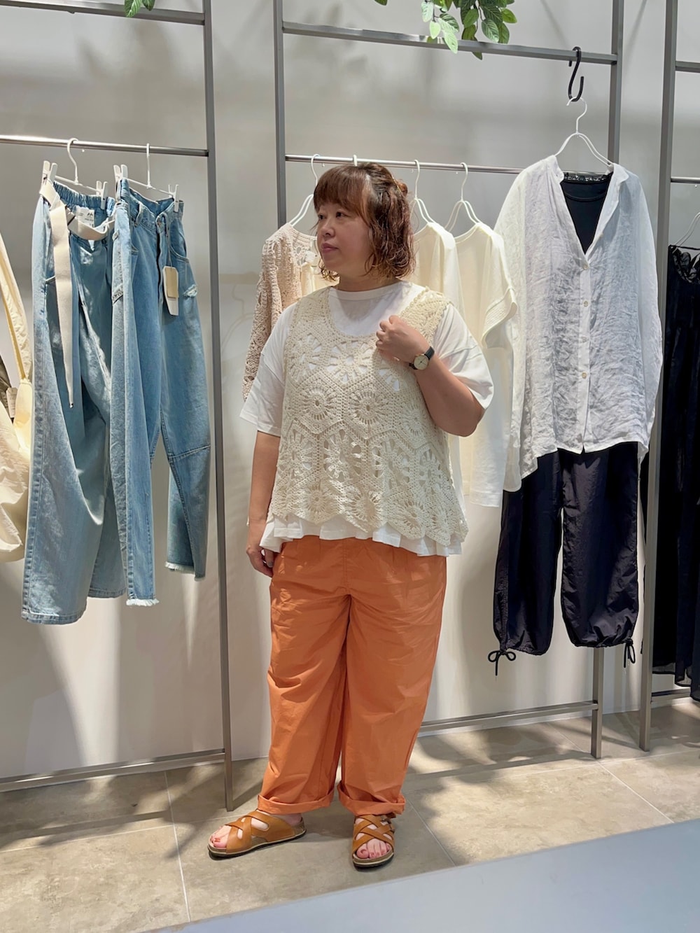 ホワイト系のTシャツ/カットソー、ベージュ系のベスト、オレンジ系のパンツを着用したレディースの夏コーディネートの2枚目の写真