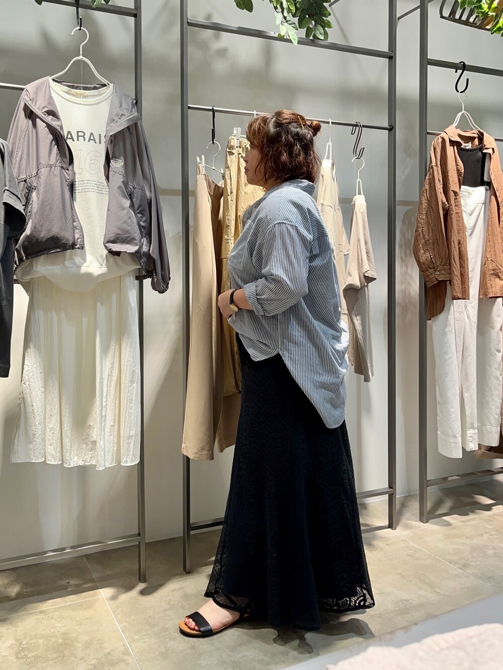 ブルー系のシャツ/ブラウス、ブラック系のトートバッグ、ブラック系のスカートを着用したレディースの夏コーディネートの3枚目の写真