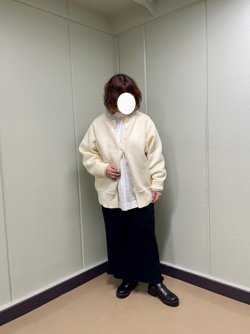 ホワイト系のニット/セーター、ホワイト系のシャツ/ブラウス、ブラック系のスカートを着用したレディースの冬コーディネートの2枚目の写真