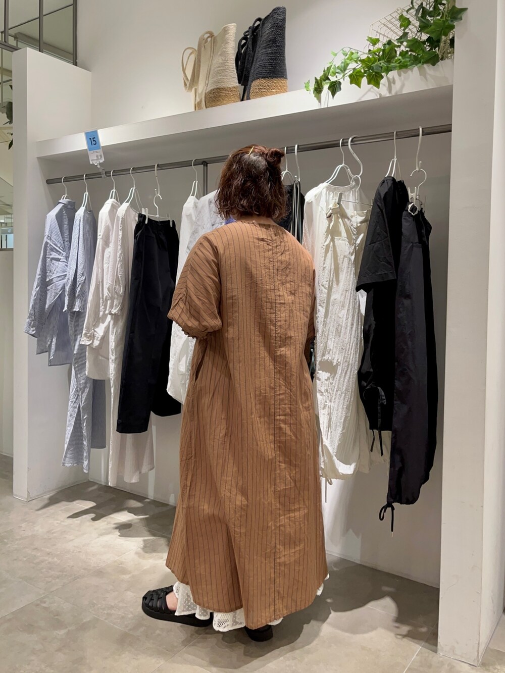 ブラウン系のワンピース、ホワイト系のスカート、ブラック系のショルダーバッグを着用したレディースの夏コーディネートの3枚目の写真