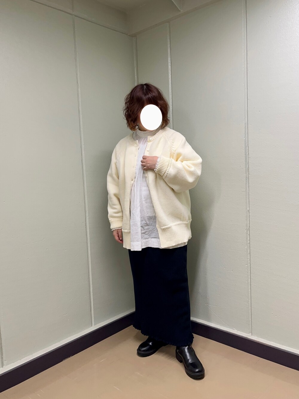 ホワイト系のニット/セーター、ホワイト系のシャツ/ブラウス、ブラック系のスカートを着用したレディースの冬コーディネートの3枚目の写真