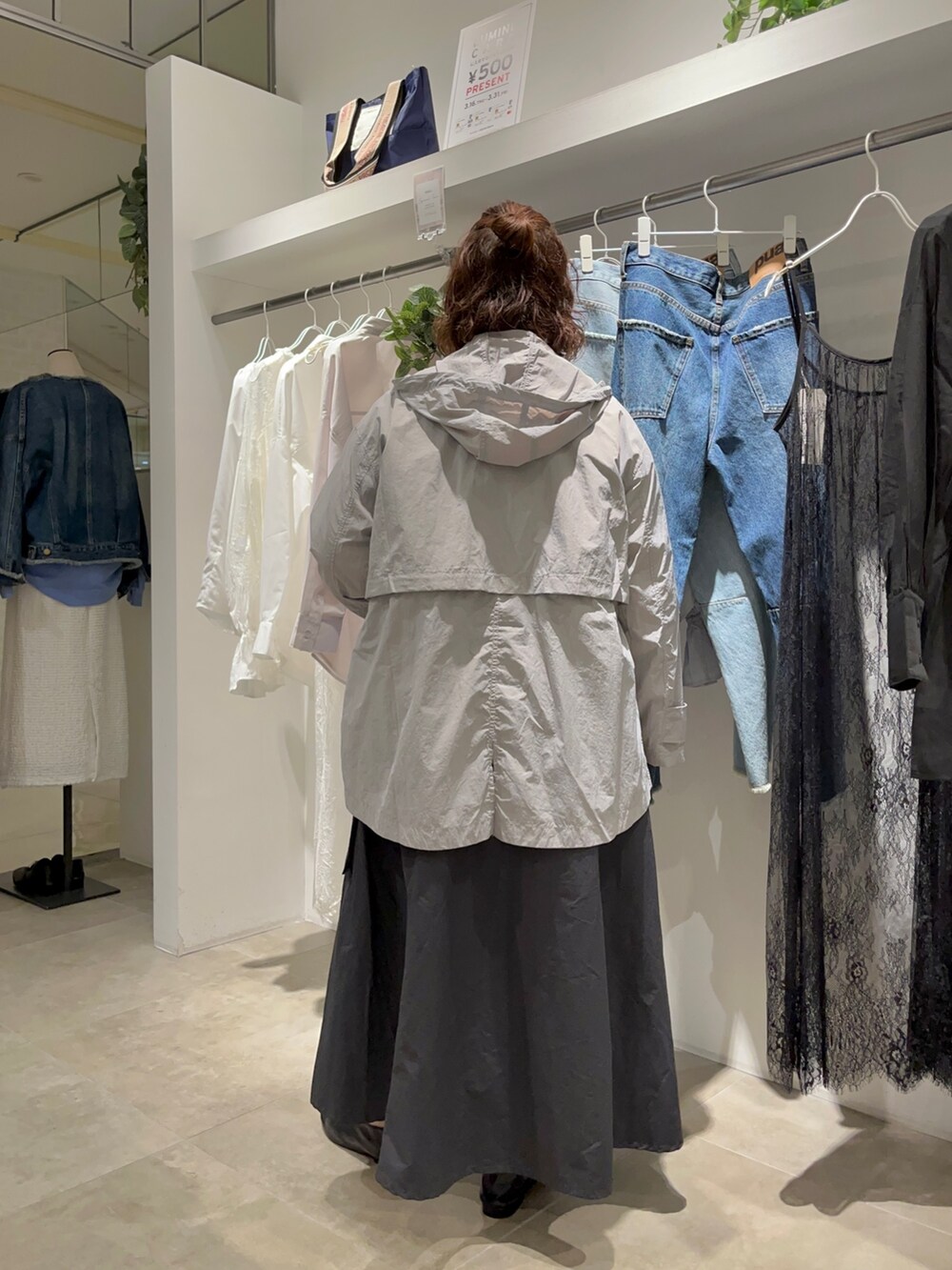 ホワイト系のシャツ/ブラウス、ブラック系のワンピース/ドレス、グレー系のマウンテンパーカーを着用したレディースの春コーディネートの3枚目の写真