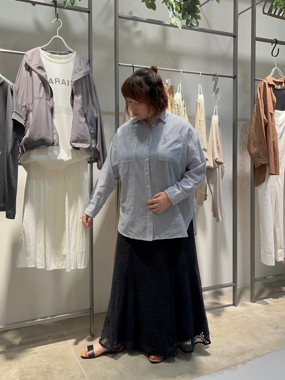 ブルー系のシャツ/ブラウス、ブラック系のトートバッグ、ブラック系のスカートを着用したレディースの夏コーディネートの4枚目の写真