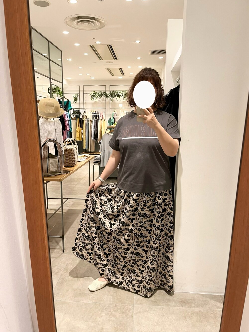 グレー系のTシャツ/カットソー、ベージュ系のトートバッグ、ベージュ系のスカートを着用したレディースの夏コーディネートの2枚目の写真