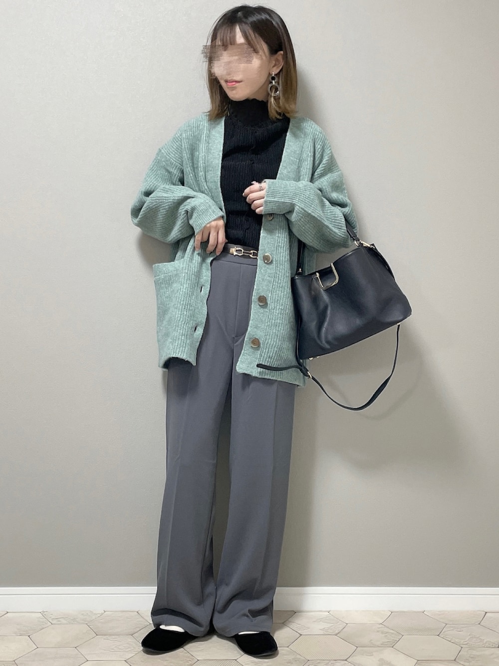 グレー系のスラックス、グリーン系のカーディガン/ボレロ、ブラック系のバレエシューズを着用したレディースの秋コーディネートの3枚目の写真
