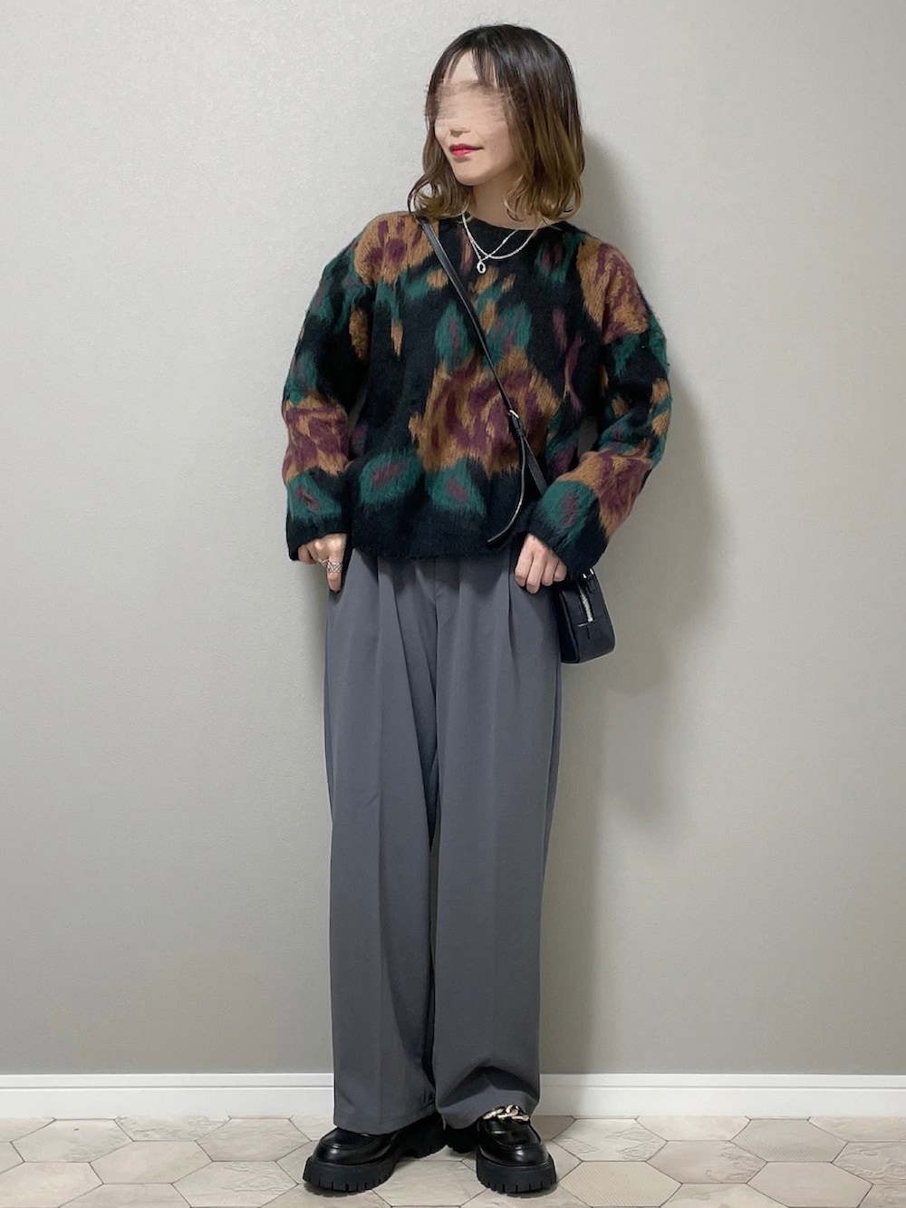 グレー系のスラックス、ブラック系のローファー、ブラック系のニット/セーターを着用したレディースの秋コーディネートの3枚目の写真