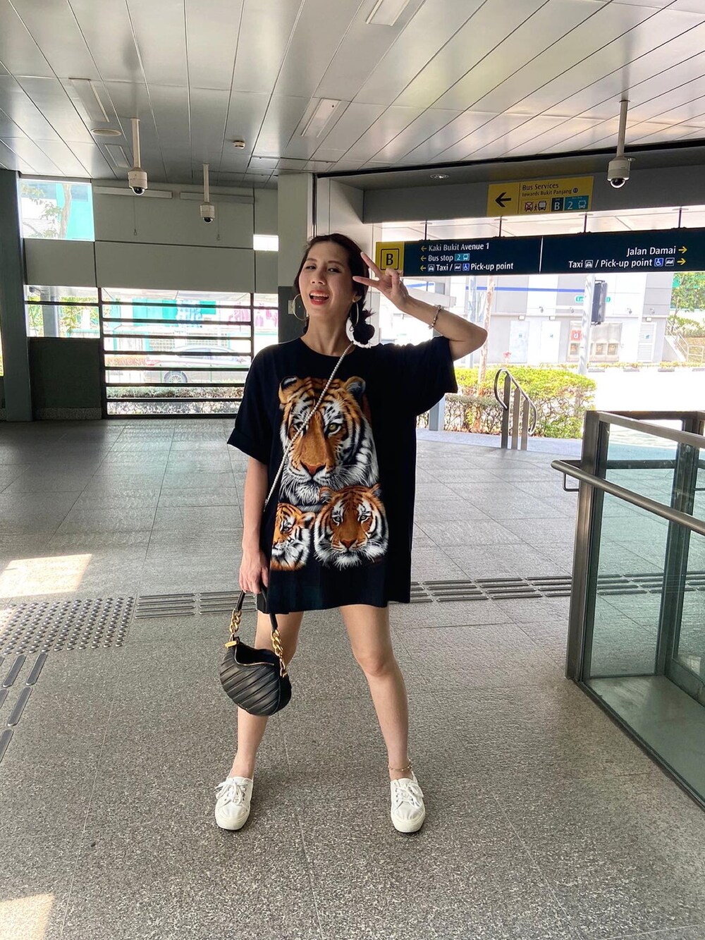 ブラック系のハンドバッグ、ホワイト系のスリッポン、シルバー系のブレスレットを着用したレディースの秋コーディネートの2枚目の写真