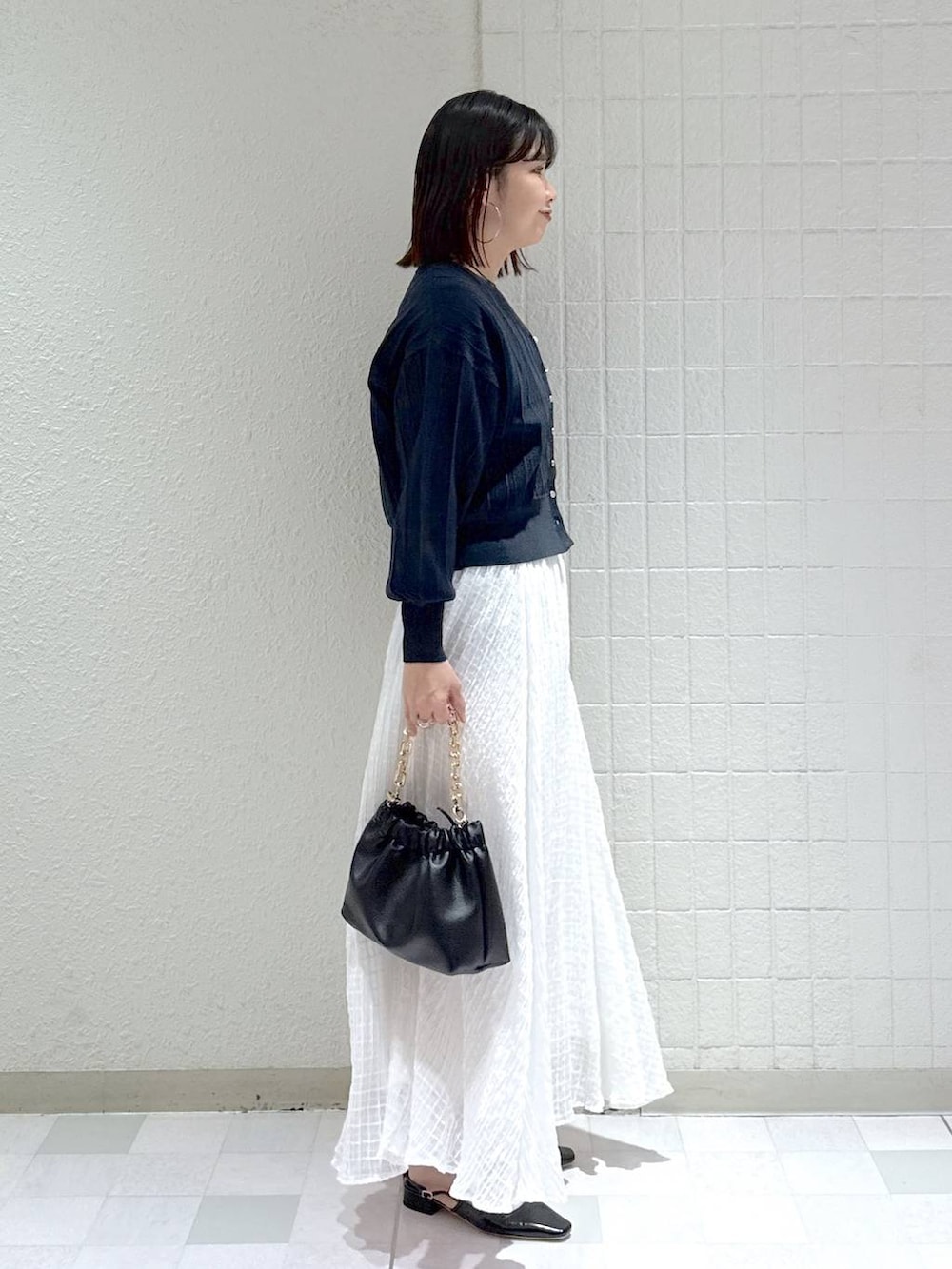 ブルー系のカーディガン/ボレロ、ブラック系のショルダーバッグ、ブラック系のパンプスを着用したレディースの春コーディネートの3枚目の写真