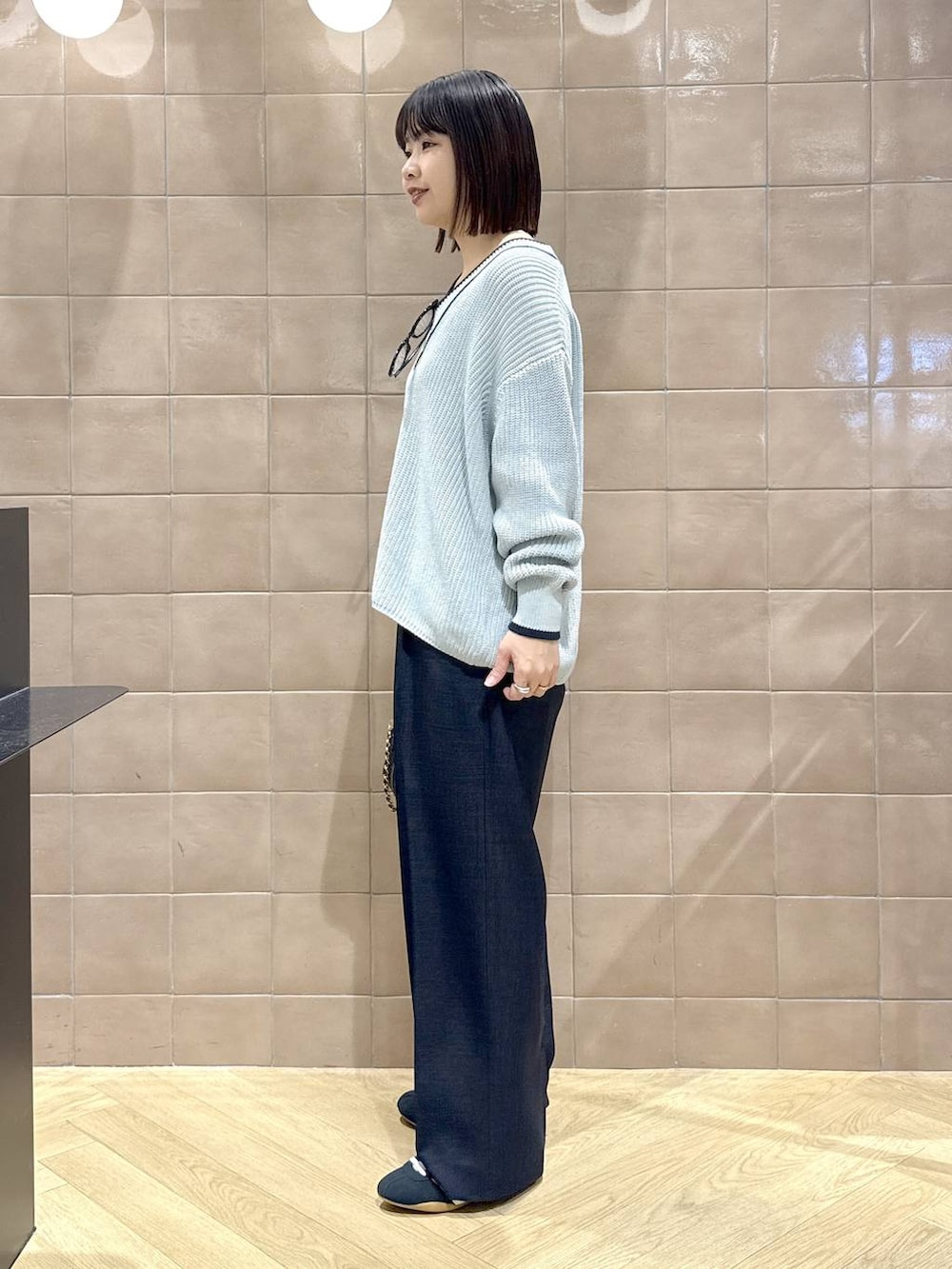 ブラック系のスニーカー、ブルー系のスラックス、ブルー系のニット/セーターを着用したレディースの冬コーディネートの5枚目の写真