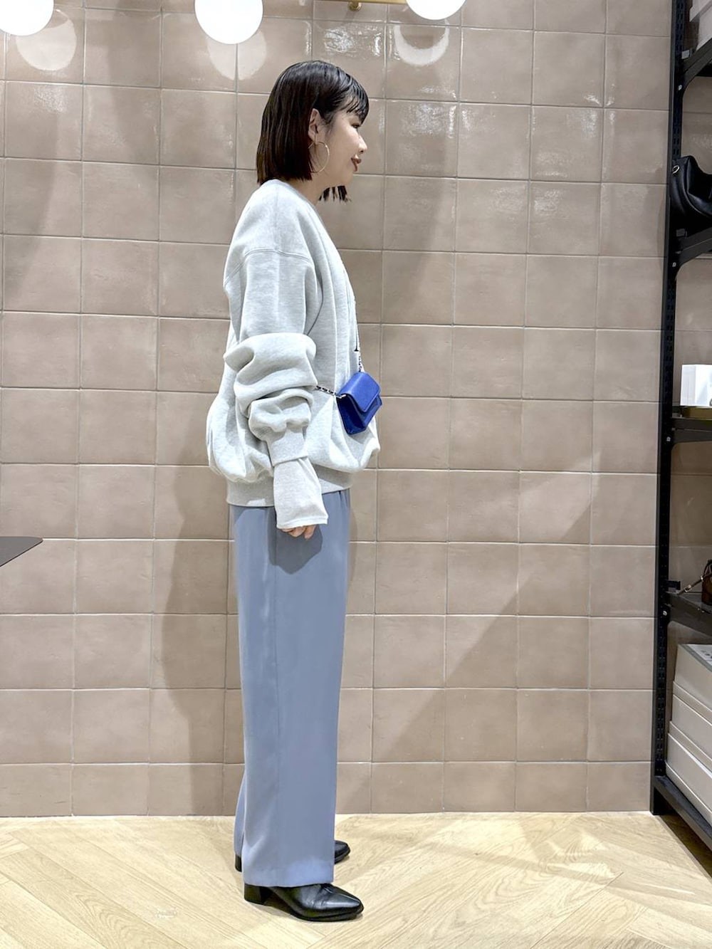 グレー系のTシャツ/カットソー、ブラック系のブーツ、ブルー系のスラックスを着用したレディースの秋コーディネートの3枚目の写真