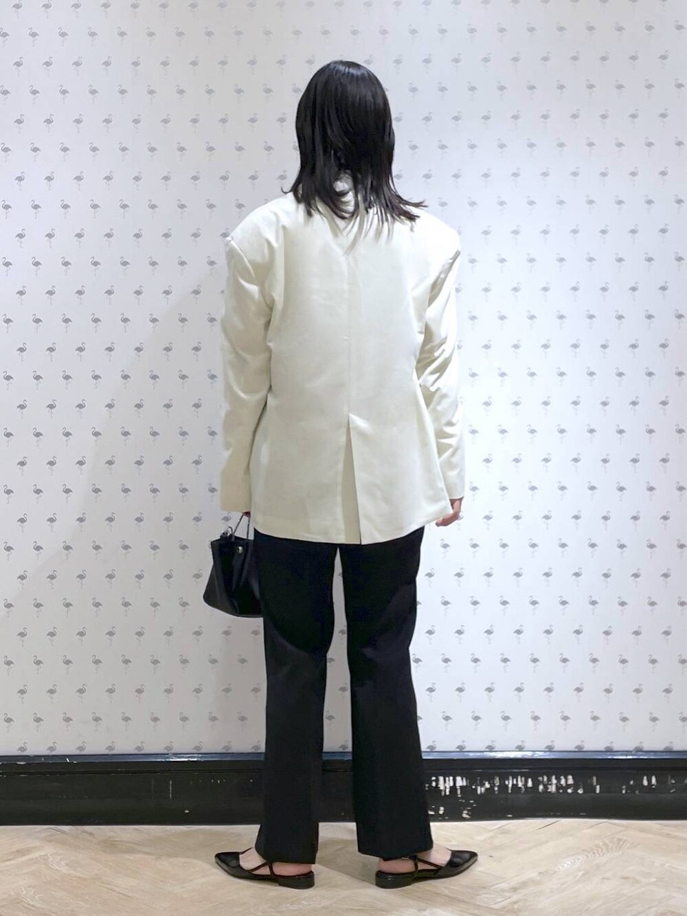 ホワイト系のシャツ/ブラウス、ブラック系のスーツセット、ブラック系のショルダーバッグを着用したレディースの冬コーディネートの3枚目の写真