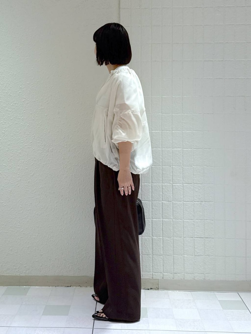 ブラック系のボストンバッグ、ホワイト系のブルゾン、ブラック系のサンダルを着用したレディースの春コーディネートの5枚目の写真