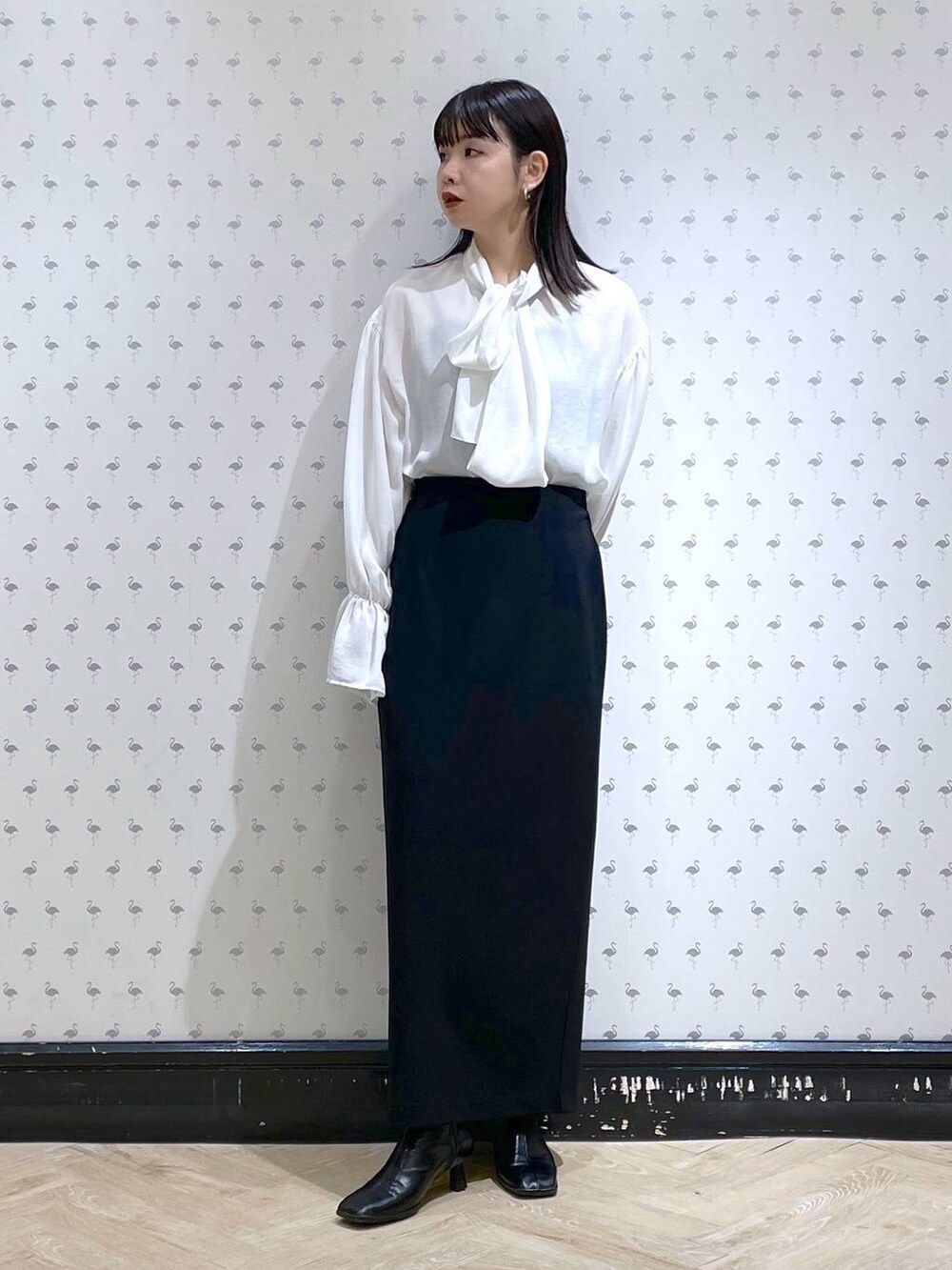 ブラック系のショルダーバッグ、ブラック系のブーツ、ブラック系のスカートを着用したレディースの冬コーディネートの8枚目の写真