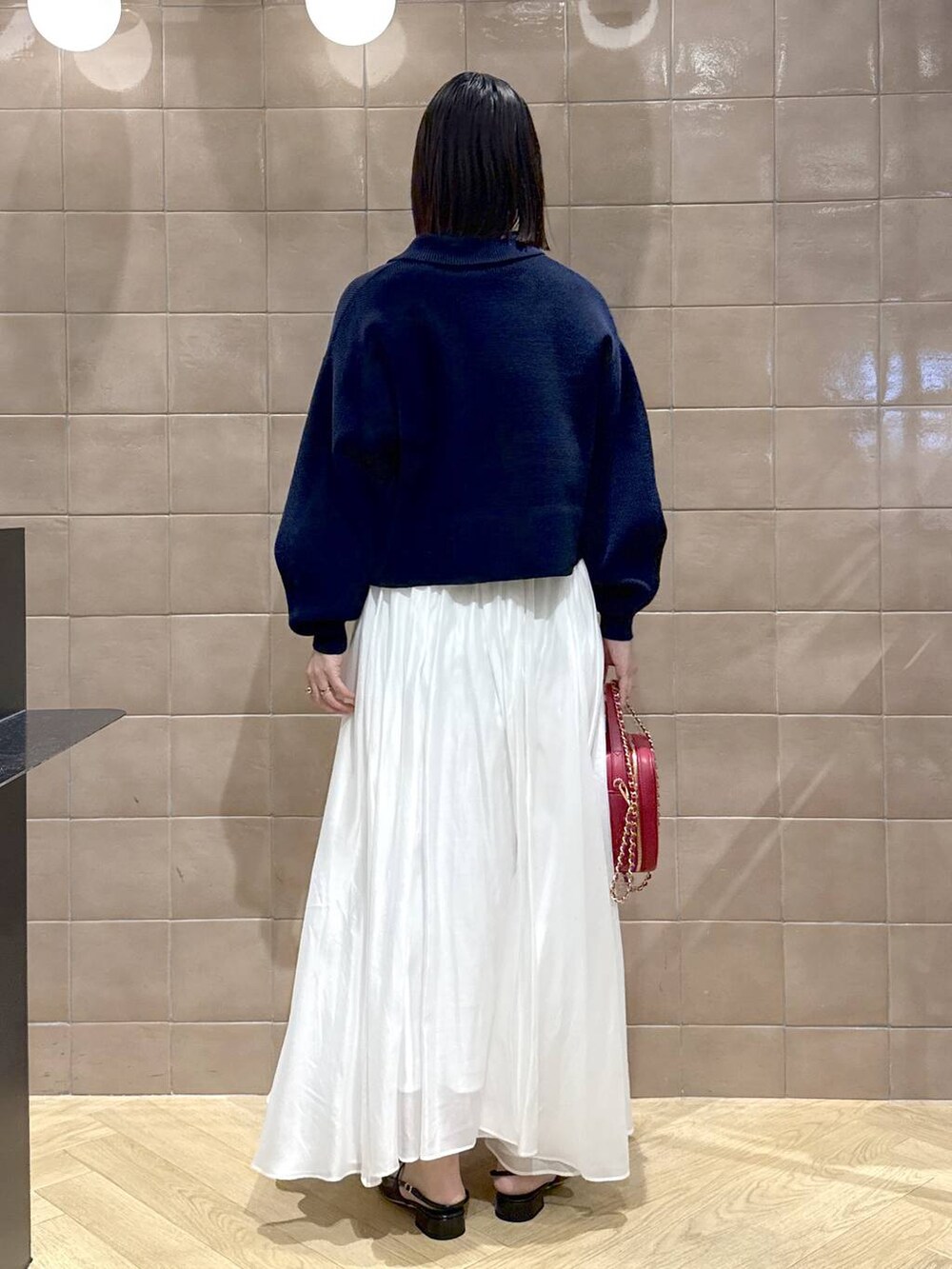 ホワイト系のスカート、ブルー系のカーディガン/ボレロ、ブラック系のその他シューズを着用したレディースの冬コーディネートの4枚目の写真