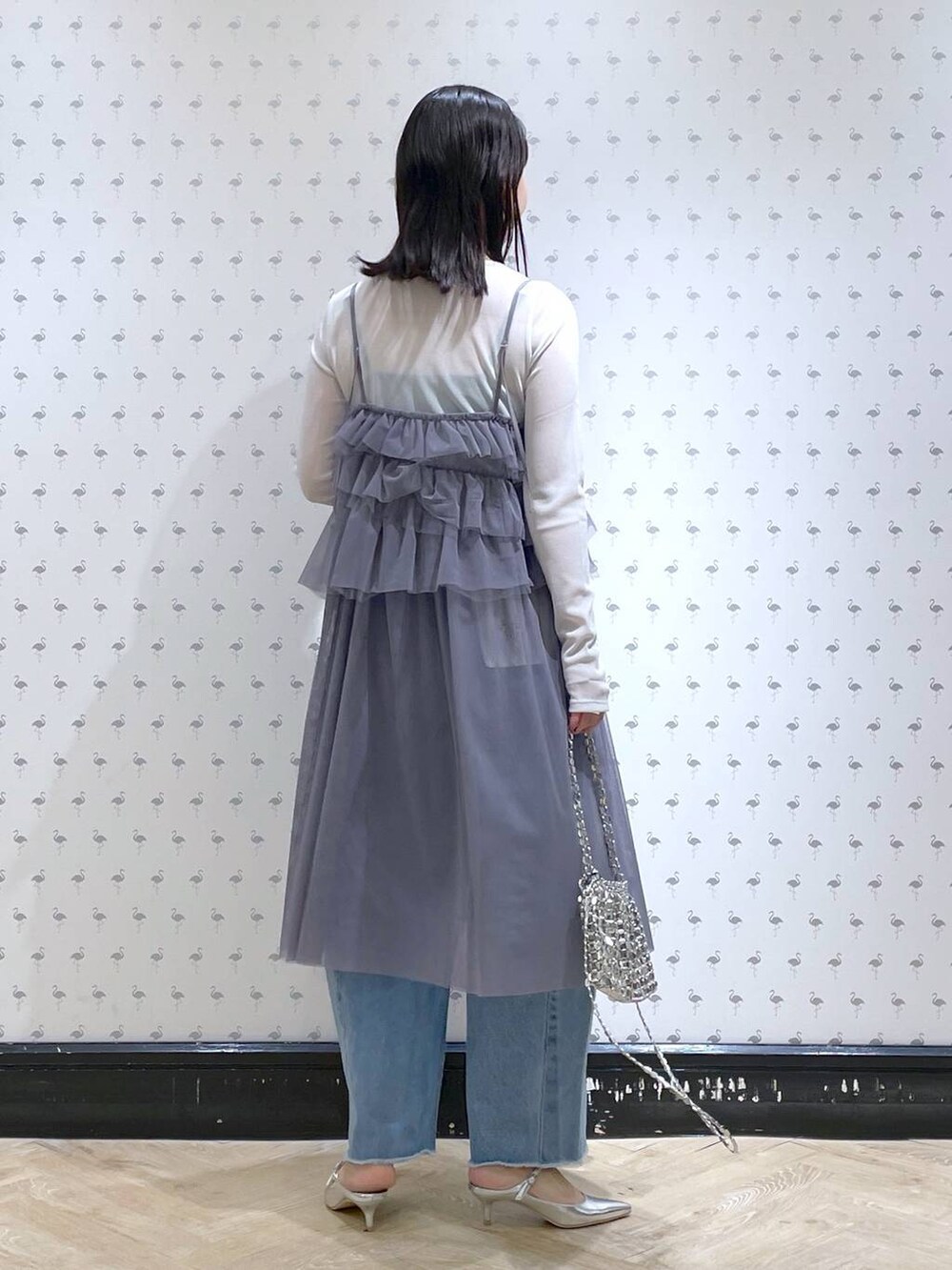 シルバー系のサンダル、ブルー系のデニムパンツ、シルバー系のショルダーバッグを着用したレディースの冬コーディネートの3枚目の写真