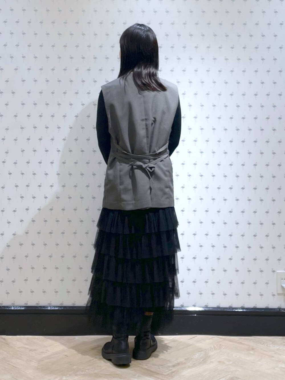 ブラック系のTシャツ/カットソー、グレー系のベスト、ブラック系のスカートを着用したレディースの冬コーディネートの5枚目の写真