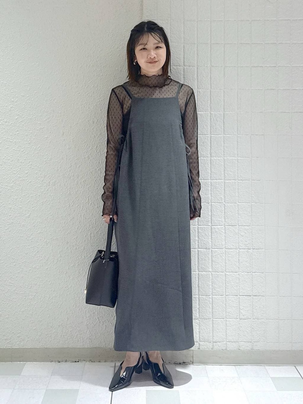 ブラック系のTシャツ/カットソー、グレー系のワンピース、ブラック系のパンプスを着用したレディースの春コーディネートの2枚目の写真