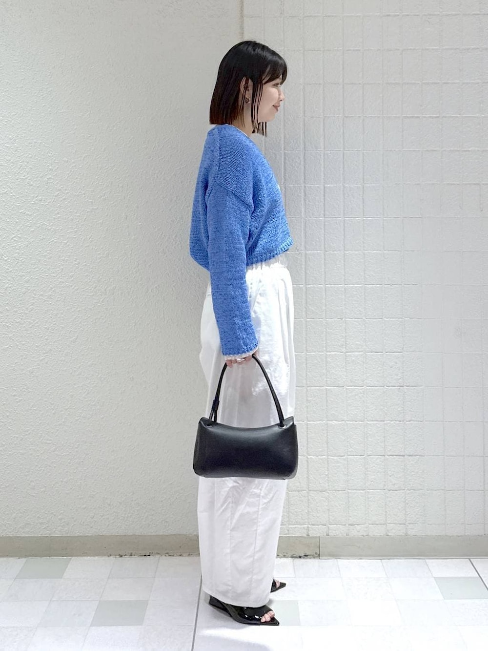 ホワイト系のTシャツ/カットソー、ブラック系のショルダーバッグ、ブルー系のカーディガン/ボレロを着用したレディースの春コーディネートの3枚目の写真