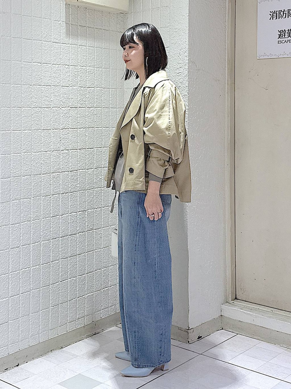 ブルー系のデニムパンツ、グレー系のカーディガン/ボレロ、ベージュ系のトレンチコートを着用したレディースの冬コーディネートの5枚目の写真