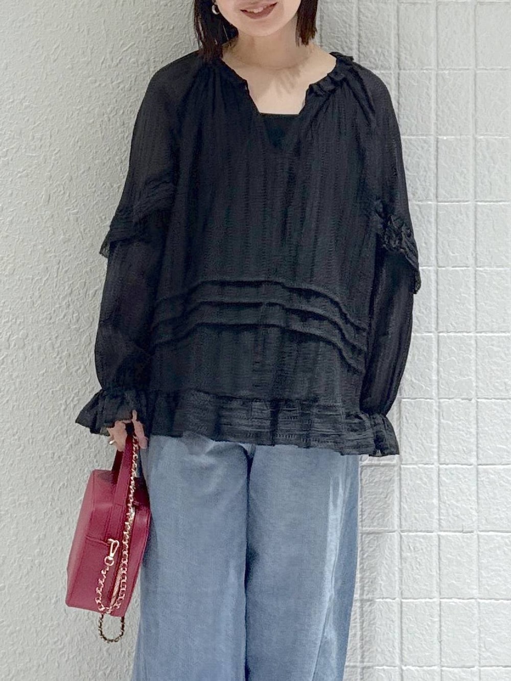 ブルー系のデニムパンツ、ブラック系のシャツ/ブラウス、ブラック系のパンプスを着用したレディースの春コーディネートの5枚目の写真