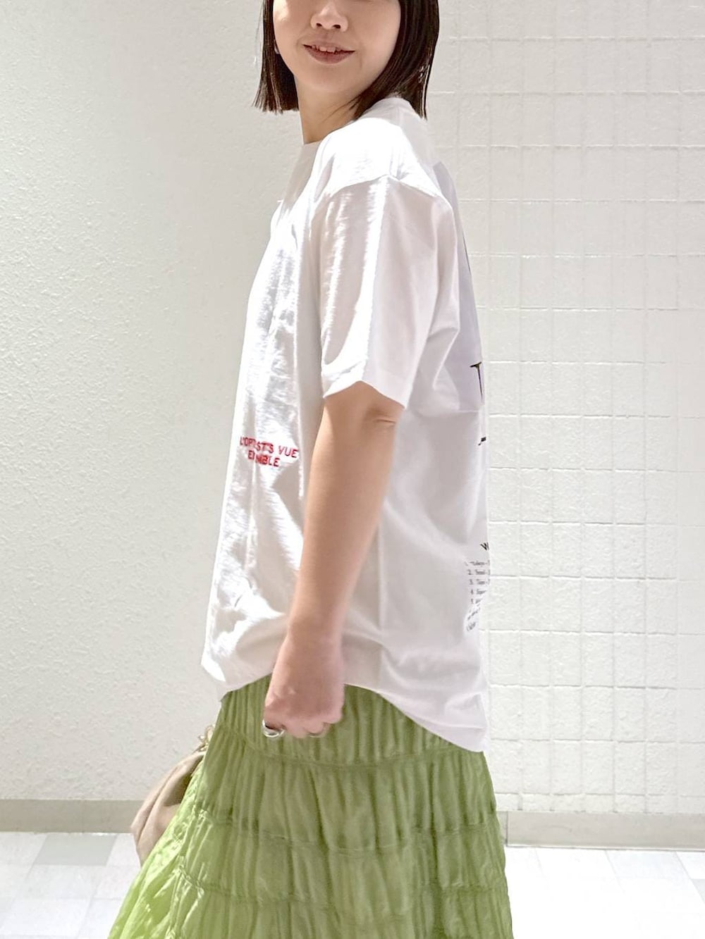 ベージュ系のショルダーバッグ、グリーン系のスカート、ブラック系のその他シューズを着用したレディースの冬コーディネートの6枚目の写真