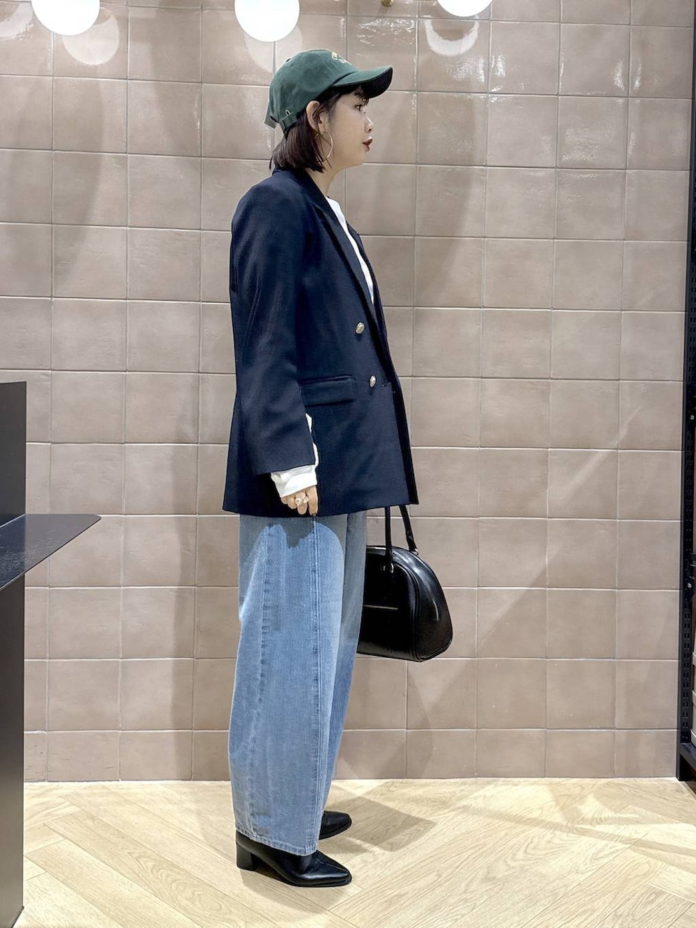 ブルー系のデニムパンツ、ブラック系のブーツ、ブルー系のテーラードジャケットを着用したレディースの秋コーディネートの3枚目の写真