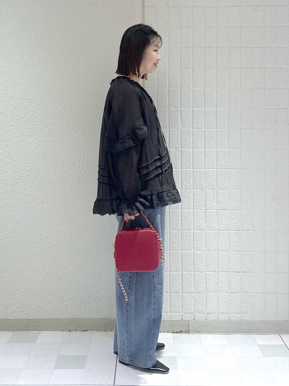 ブルー系のデニムパンツ、ブラック系のシャツ/ブラウス、ブラック系のパンプスを着用したレディースの春コーディネートの2枚目の写真